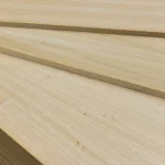 Stack of oak veneered MDF boards on a pallet, side view.