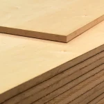 Corner of a 19 mm Alder veneered MDF board, top view of stacked sheets.