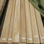 Long sheets of sawn elm veneer laid out on a pallet with labels