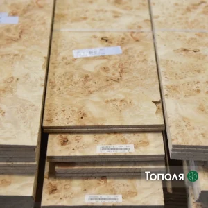 Texture of burl poplar sawn veneer sheets stacked, showing unique eye pattern.