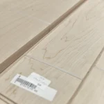 Close-up of sawn maple veneer texture with a barcode label