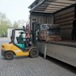 Forklift loading a pallet of sawn veneer into a truck