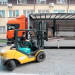 Навантажувач переміщує палету з пиляним шпоном біля вантажівки на складі WoodWay Expert.