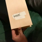 Sheet of sawn alder veneer in hand, demonstrating flexibility and thickness
