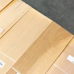 Top view of sawn alder veneer sheets with product labels.