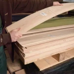 Checking the flexibility and quality of sawn ash veneer by a warehouse worker.