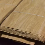 Edge view of a sliced elm veneer pack showing the sheet thickness of 0.6 mm