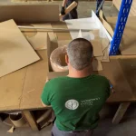 WoodWay Expert warehouse worker packing a roll of natural sliced birch veneer