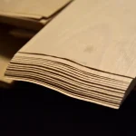 Sheet edges in a pack of sliced beech veneer showing 0.6 mm thickness.