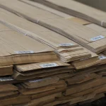 Edges of oak veneer bundles showing the 0.6 mm sheet thickness.