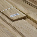 Edge of a sliced oak veneer pack showing 0.6 mm thickness with a label