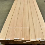 Long sheets of natural sliced red oak veneer in a pack on a pallet.