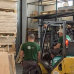 Forklift and workers at the WoodWay Expert lumber warehouse.