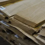 Edge of sliced oak veneer pack showing the 0.6 mm sheet thickness