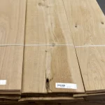 Bundles of sliced oak veneer with knots, strapped and labeled with barcodes