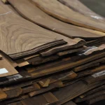 Edges of sliced American walnut veneer sheets, 0.6 mm thick, stacked.