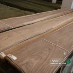 A pack of natural sliced American Walnut veneer, 0.6 mm thick, extra grade in a warehouse.