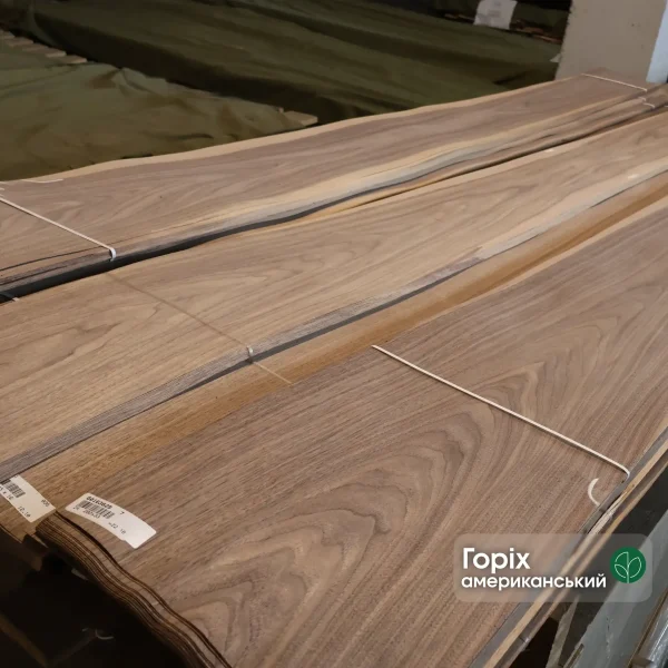A pack of natural sliced American Walnut veneer, 0.6 mm thick, extra grade in a warehouse.