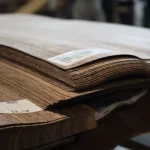 Edge of stacked sliced American Walnut veneer sheets showing 0.6 mm thickness.