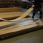 Warehouse worker demonstrating the flexibility of a sliced European Walnut veneer sheet