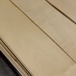 Detailed view of the texture and grain of natural sliced maple veneer.