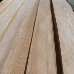 Long sheets of natural sliced European pine veneer on a work surface.