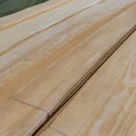 Detailed view of the light wood texture of sliced pine veneer with a strapping band.
