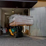 Навантажувач перевозить велику палету зі струганим шпоном береста товщиною 0,6 мм біля складу.