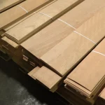 Stacked bundles of natural sliced beech veneer on a pallet.
