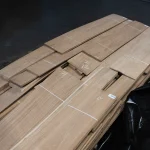 Pallet with packs of short sliced oak veneer sheets, 0.5-0.75 m long, in the warehouse.