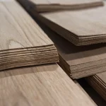 Edges of sliced oak veneer sheets showing the 1.5 mm thickness.