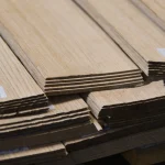 Edges of sawn oak veneer sheets showing 2.5 mm thickness.