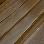 Angled view of stacked natural sliced American walnut veneer sheets 0.6 mm.