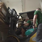 Komatsu forklift moving pallets with wood materials at the WoodWay Expert warehouse.