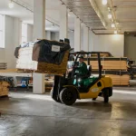 Forklift moving a pallet of sliced veneer in the WoodWay Expert warehouse.