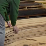 Сотрудник склада WoodWay Expert отбирает листы строганного шпона сосны для заказа.