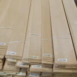 Stacked bundles of sliced alder veneer with barcodes and labels.