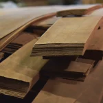 Stacked sheets of sliced American cherry veneer, side view.