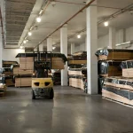Forklift moving pallets of sliced wood veneer in the WoodWay Expert warehouse.