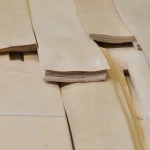 Ends of a sliced alder veneer bundle showing uniform sheet thickness.