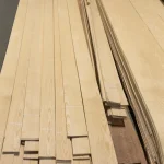 Long sheets of natural sliced white ash veneer in the warehouse.