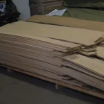Warehouse stock of natural sliced white ash veneer on wooden pallets.
