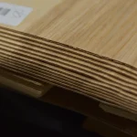 Close-up of the edge of sliced olive ash veneer sheets showing 1.5 mm thickness