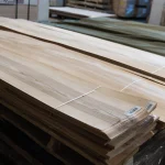 Bundle of sliced olive ash veneer sheets 2.1-3.8 m long on a pallet.