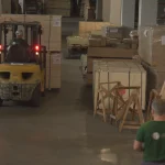 WoodWay Expert warehouse with forklift and stacked pallets of veneer and lumber.