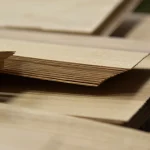 Edges of sliced olive ash veneer sheets showing 1.5 mm thickness