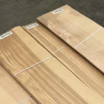 Sheets of natural sliced olive ash veneer stacked in bundles