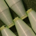 Spools of Kuper 1110 glue thread for veneer splicing arranged on a green surface