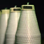 Top end view of Kuper 1220 glue thread spool in protective green mesh.