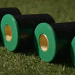 Kuper K12 glue thread spools with green plastic caps lying on the grass